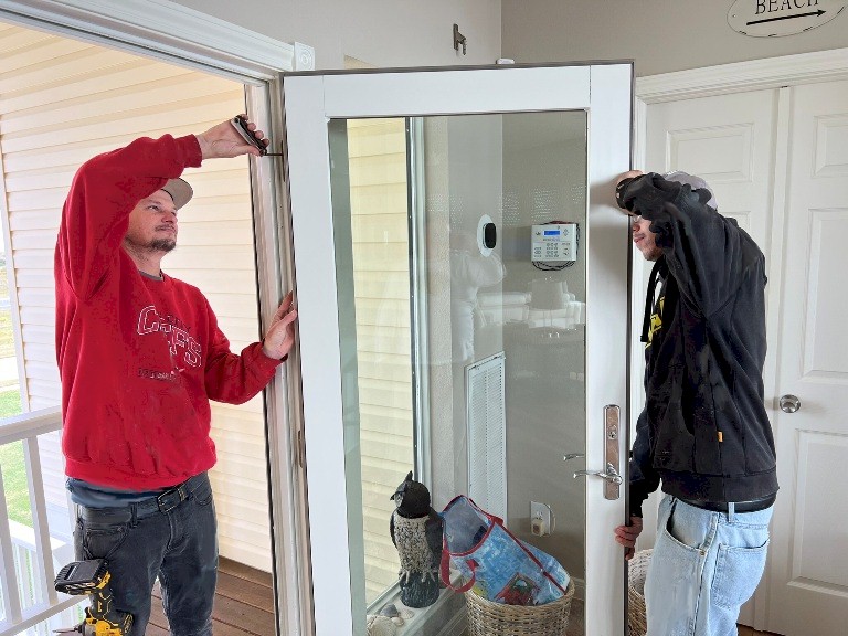 Image of Tracey Calvert crew adjusting an Andersen storm door on a Galveston beach house.   Image Copyright © 2023 Brad Larkin