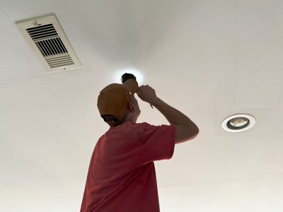 Image of Tracy Calvert Jr investigating the source of water damage on ceiling drywall in a Galveston beach house. Image Copyright © 2022 Brad Larkin