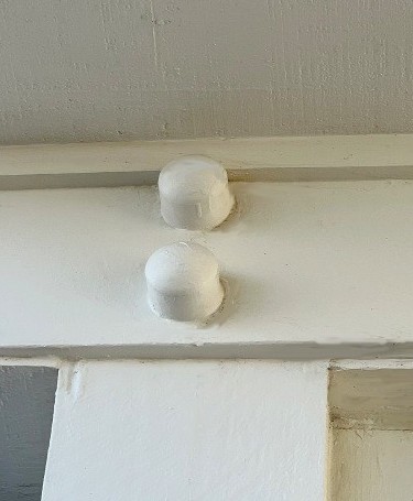 Image of plastic cap covers for exposed metal bolts attaching the piers to a Galveston beach house. Image Copyright © 2023 Brad Larkin