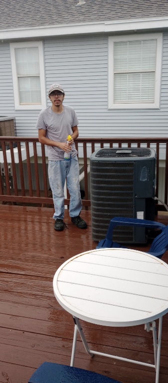 Image of Adam Calvert cleaning deck and outdoor furniture at a customer's home on Galveston island. Image Copyright © 2023 Tracy Calvert Sr
