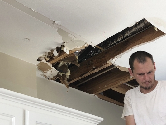 Image of Tracy Calvert Jr investigating the source of water damage behind drywall in a Galveston beach house. Image Copyright © 2021 Brad Larkin