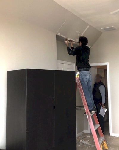 Image of Adam Calvert cutting out bad drywall in a Galveston beach house. Image Copyright © 2021 Brad Larkin