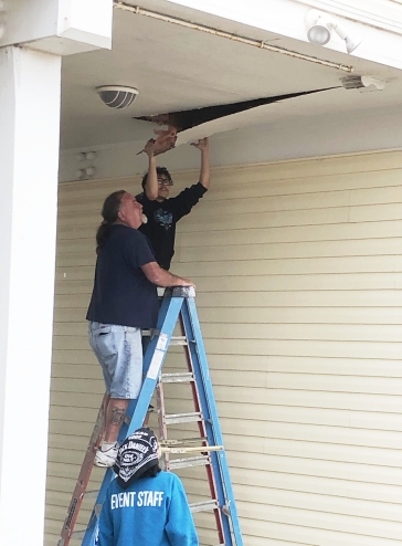Image of Tracey Calvert crew inspecting exterior soffet for water damage on a Galveston beach house.    Image Copyright © 2021 Brad Larkin