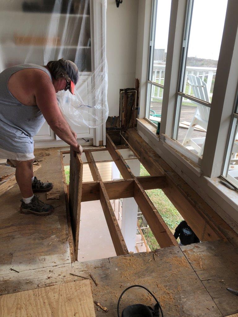In-progress image of subfloor and soffet decking removed as part of a flooring job by Tracy Calvert Home Repair and Maintenance in a Galveston beach house. Image Copyright © 2021 Brad Larkin