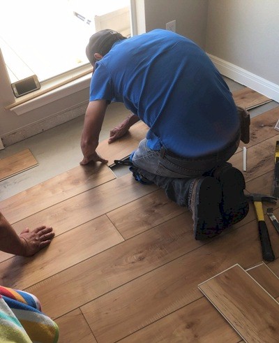 Image of Luxury Vinyl Tile (LVT) flooring going down with interlocking tongue and groove joint in a Galveston beach house.  Image Copyright © 2021 Brad Larkin