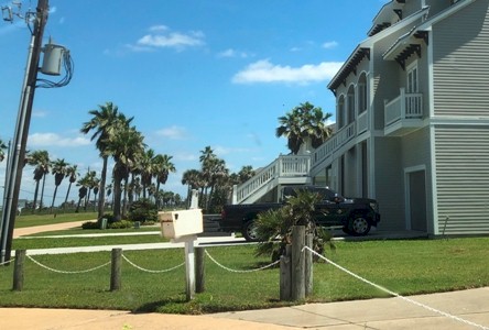 Image of bollards connected with a chain to limit parking and unauthorized vehicle access into the drive way of a Galveston beach house. Image Copyright © 2020 Brad Larkin