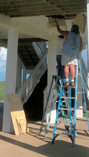 Image of Tracy Calvert crew inspecting subflooring and insulation at a Galveston beach house.  Image Copyright © 2021 Brad Larkin