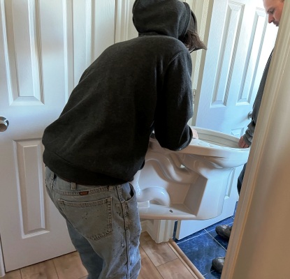 Image of Tracy Calvert crew replacing a toilet in a Galveston beach house.  Image Copyright © 2023 Brad Larkin